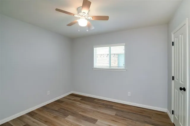 an empty room with wooden floor and window