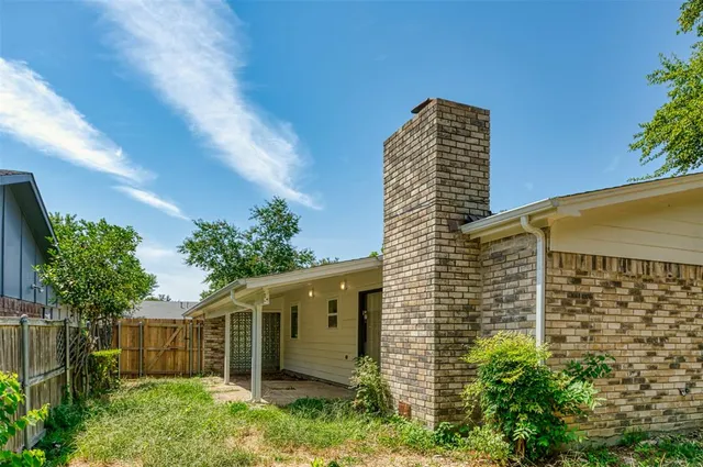 a view of a house with a yard and potted plants