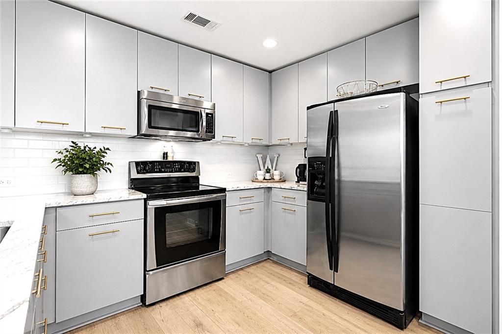 3300 Windy Ridge Parkway Southeast, Unit 1112 Atlanta, GA 30339 - Photo 7 of 43 a kitchen with stainless steel appliances a refrigerator sink and microwave