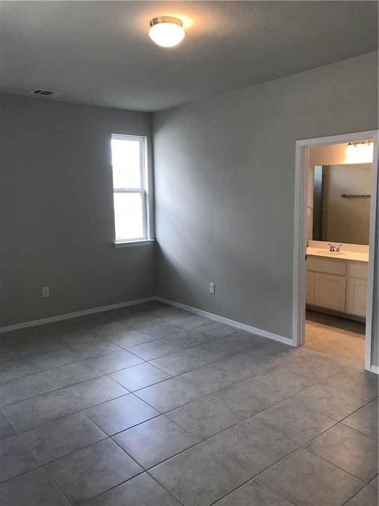 1353 Goforth Road Kyle, TX 78640 - Photo 13 of 24 an empty room with a bathroom and windows