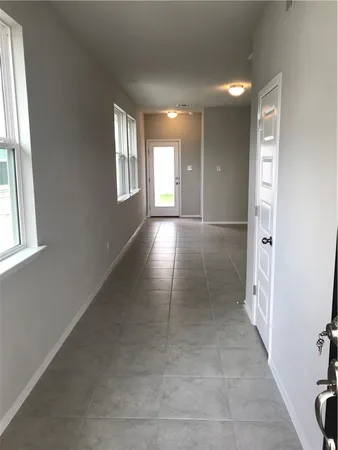 a view of hallway with windows and chandelier