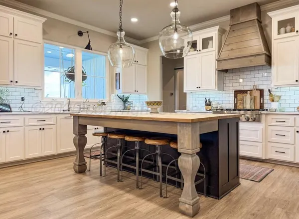 a kitchen with stainless steel appliances a dining table chairs and wooden floor