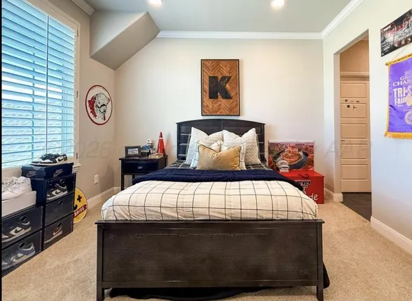 a bedroom with a bed and a lamp on dresser
