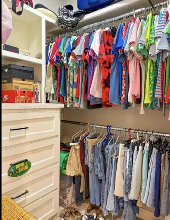 a view of walk in closet with clothes and shoes