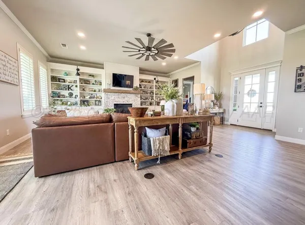 a living room with furniture a flat screen tv and wooden floor