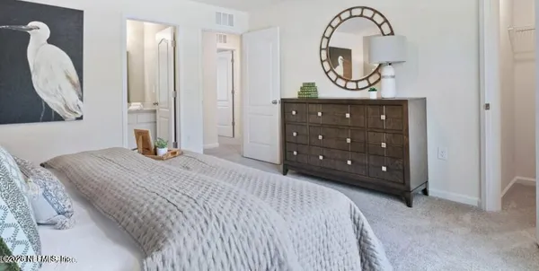 a bedroom with a bed a mirror and a table