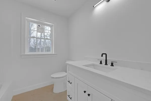 an empty room with wooden floor ceiling fan and windows