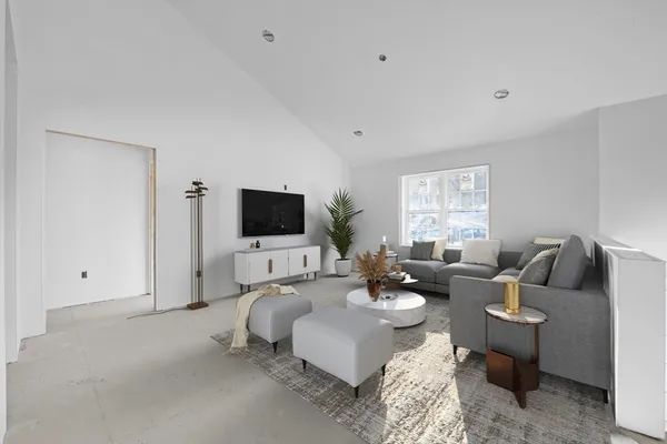 a living room with furniture a flat screen tv and a window