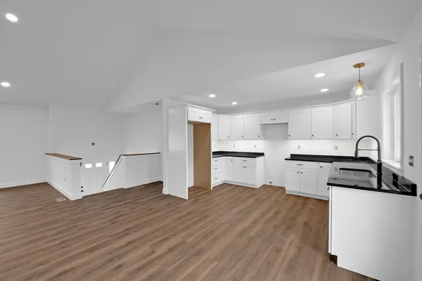 a kitchen with granite countertop white cabinets and white appliances
