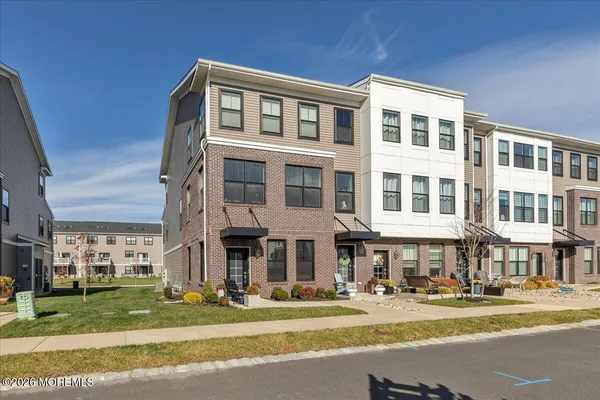a front view of a building with a garden and plants