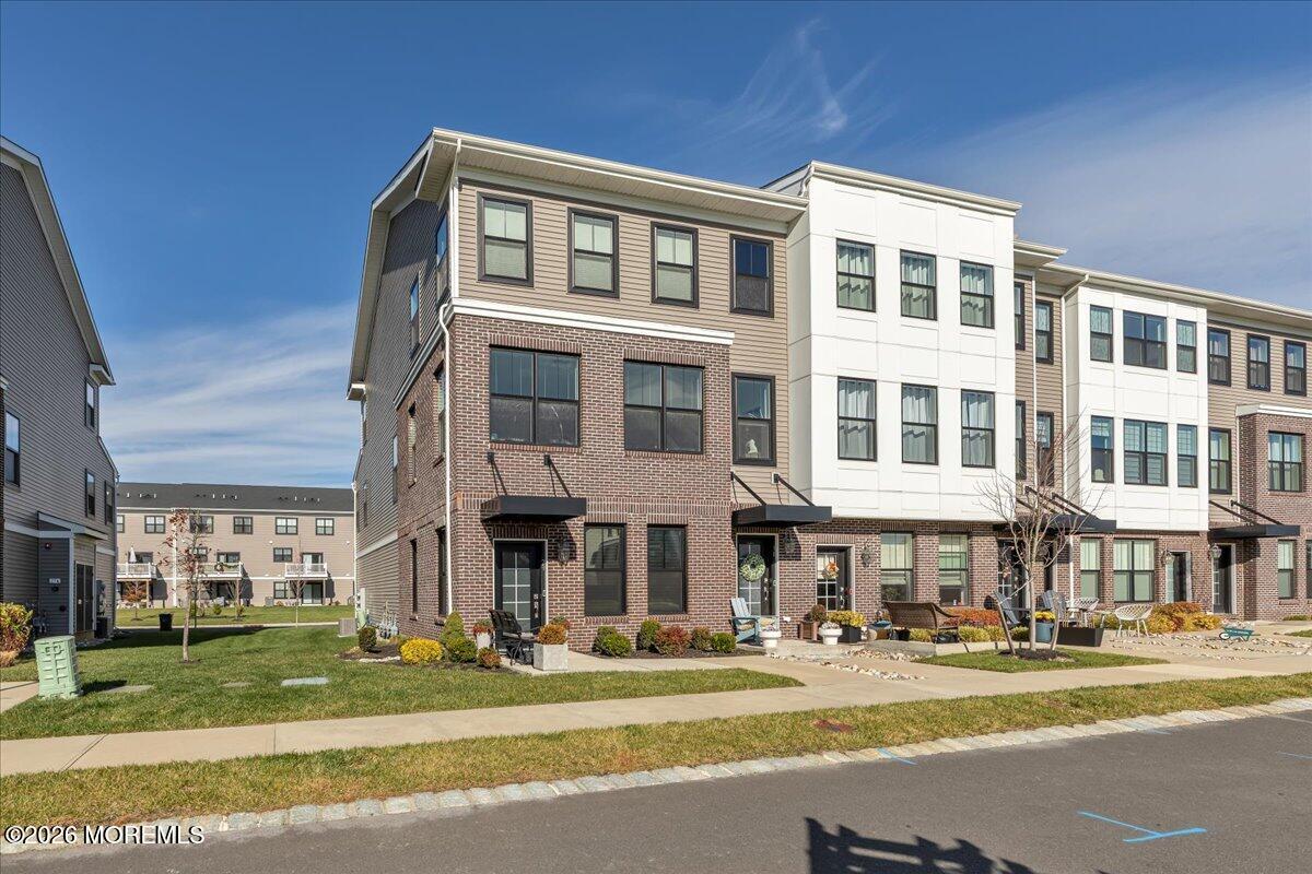 a front view of a building with a garden and plants