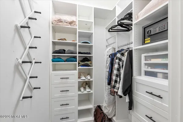 a view of walk in closet with clothes and shoes
