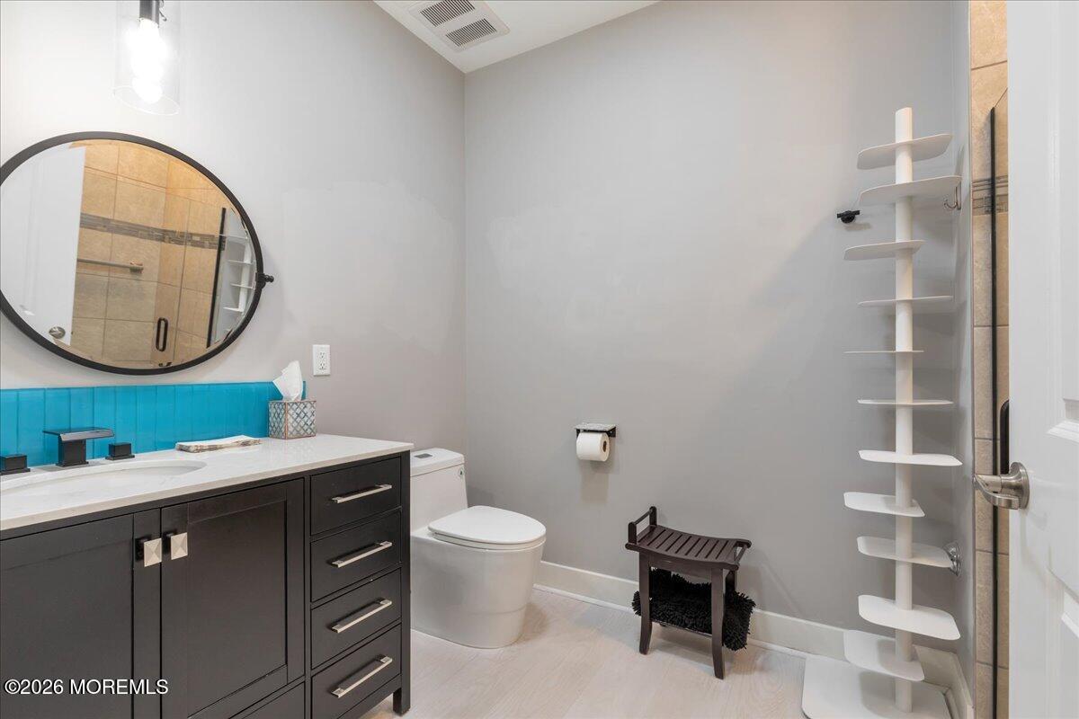 29 Midway Road North Tinton Falls, NJ 07724 - Photo 30 of 37 a bathroom with a toilet a sink and a mirror