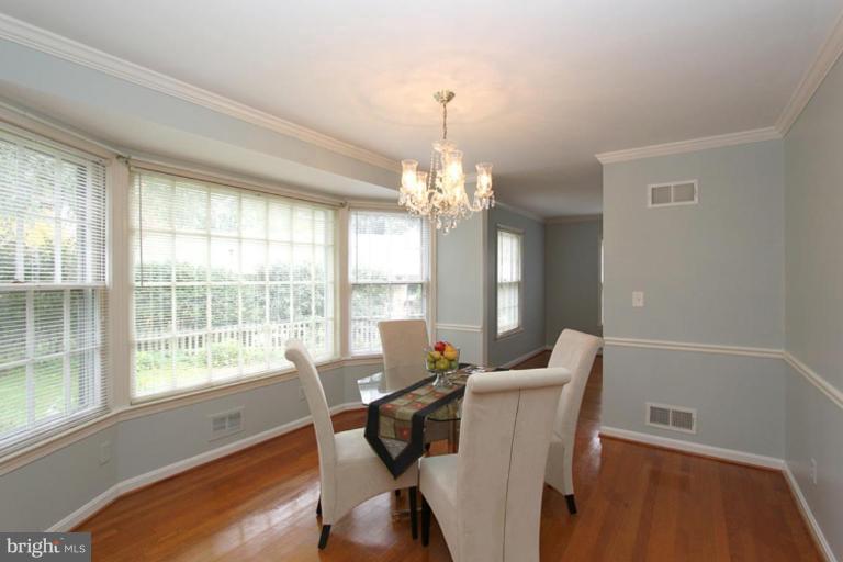 9518 Clement Road Silver Spring, MD 20910 - Photo 11 of 27 a view of a dining room with furniture a chandelier and wooden floor