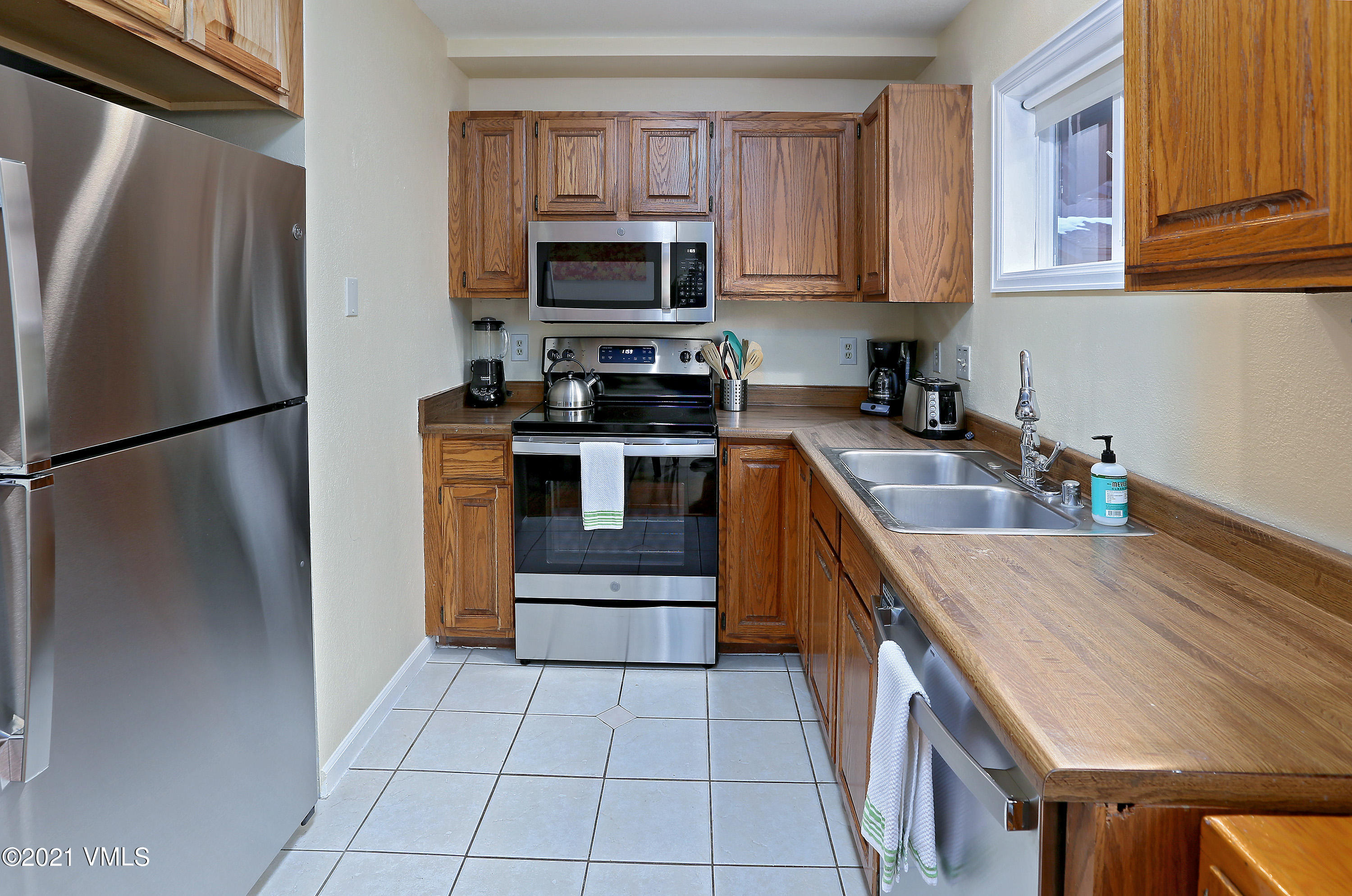 44 Eagle Road, Unit 2 Avon, CO 81620 - Photo 7 of 17 a kitchen with stainless steel appliances granite countertop a refrigerator stove and a sink