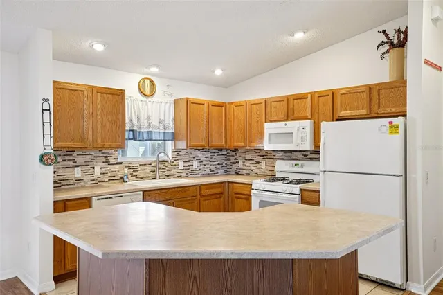 a kitchen with stainless steel appliances granite countertop a sink a stove and refrigerator