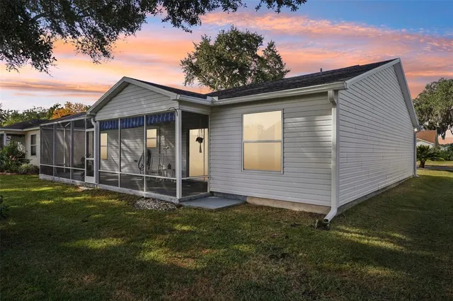 a view of backyard of house with wooden fence