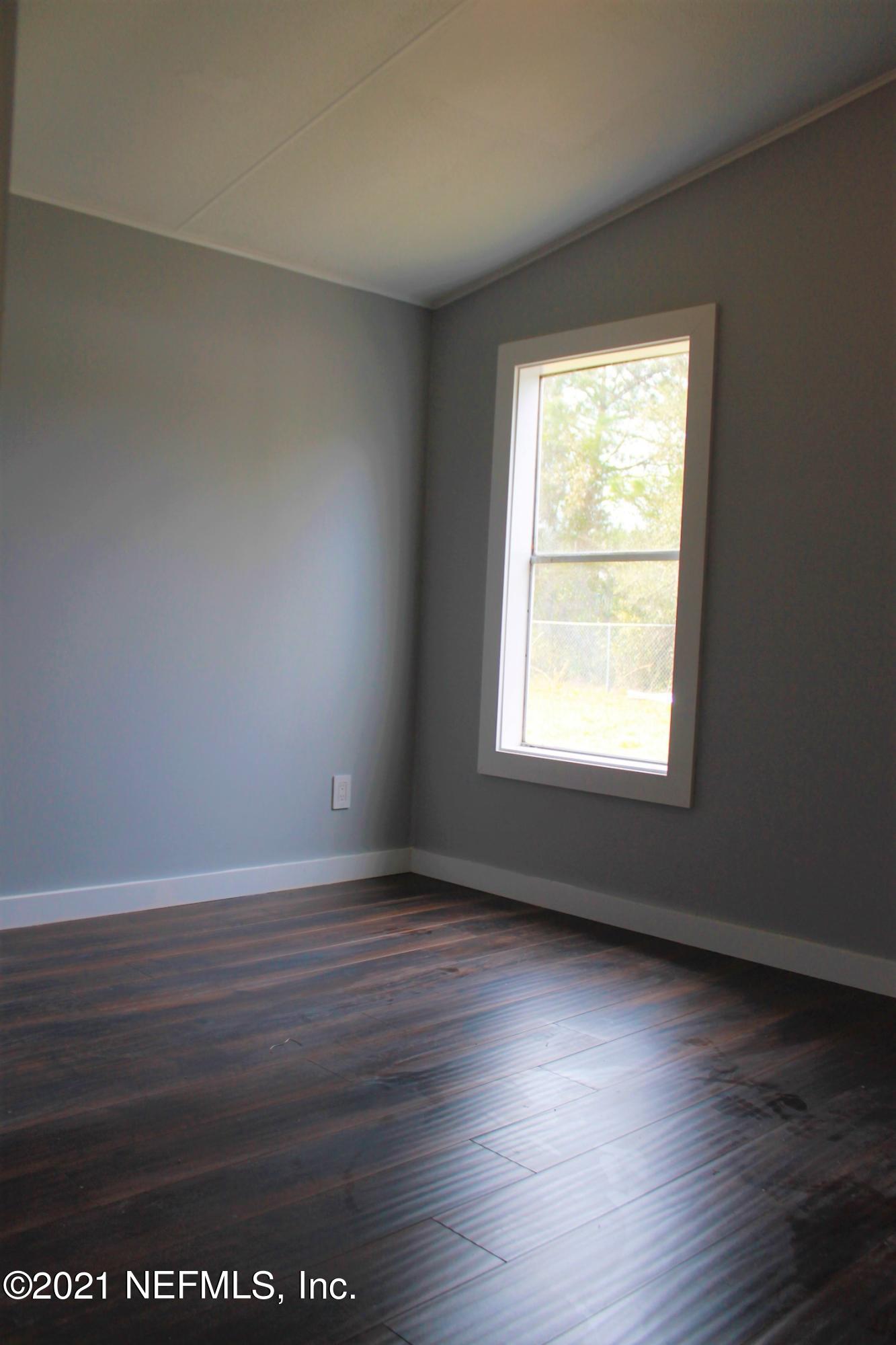 16006 Shellcracker Road Jacksonville, FL 32226 - Photo 24 of 41 an empty room with wooden floor and windows