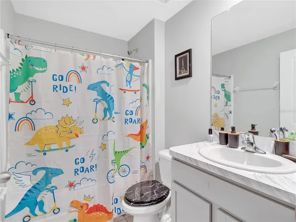a bathroom with a sink a toilet and a shower curtain