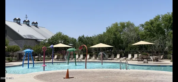 a swimming pool with table and chairs under an umbrella