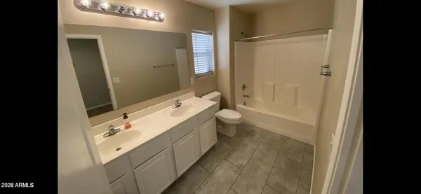 a bathroom with a granite countertop sink a toilet and shower