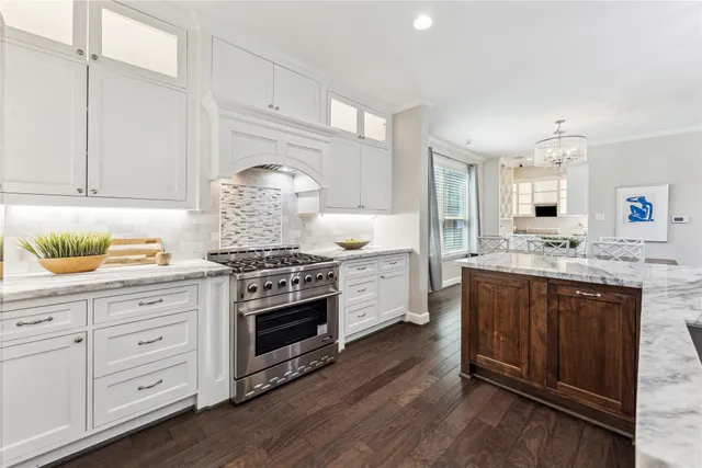 a kitchen with stainless steel appliances granite countertop a stove a sink and a refrigerator