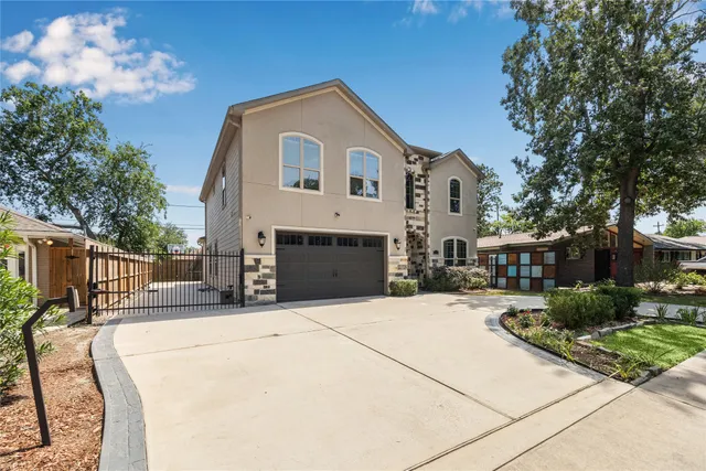 a view of a white house with a yard and potted plants