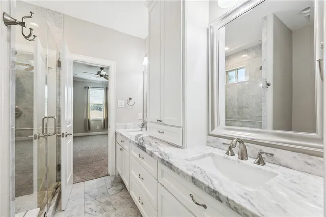 a bathroom with a granite countertop double vanity sink mirror and double