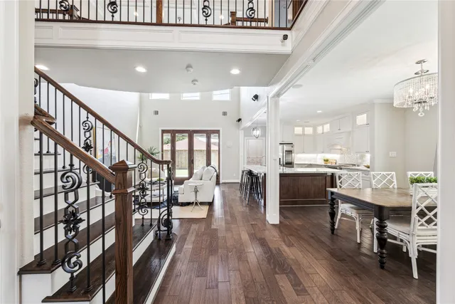 a living room with lots of wooden furniture and a dining table with wooden floor