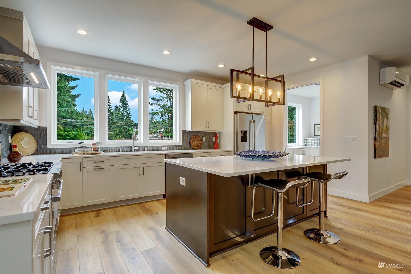 3838 36th Avenue West Seattle, WA 98199 - Photo 3 of 24 a kitchen with kitchen island granite countertop a sink cabinets and wooden floor