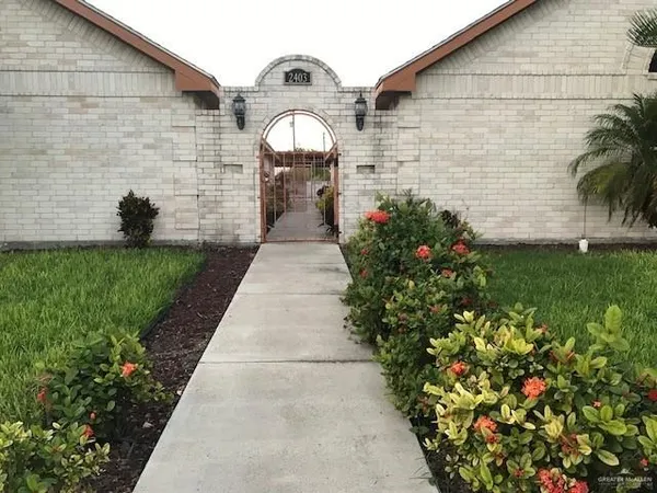 a pathway of a house with a yard