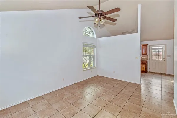 an empty room with windows and fan