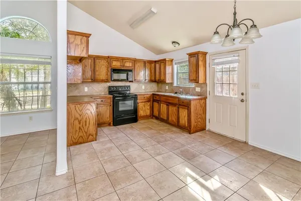 a large kitchen with stainless steel appliances granite countertop a stove and a sink