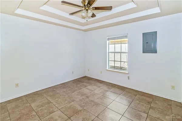 a view of an empty room with chandelier fan
