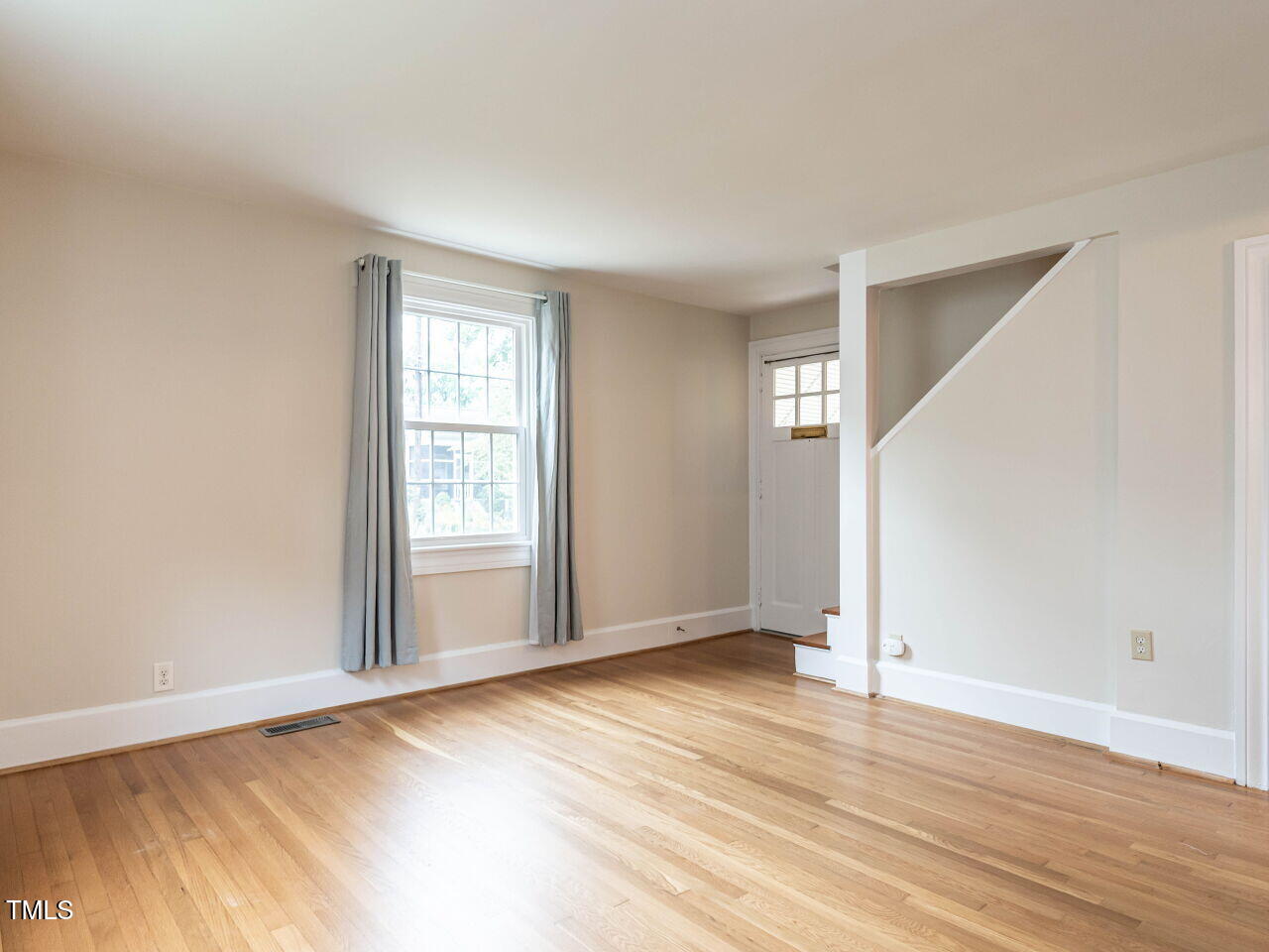 412 Morrison Avenue Raleigh, NC 27608 - Photo 3 of 26 a view of an empty room with wooden floor and a window