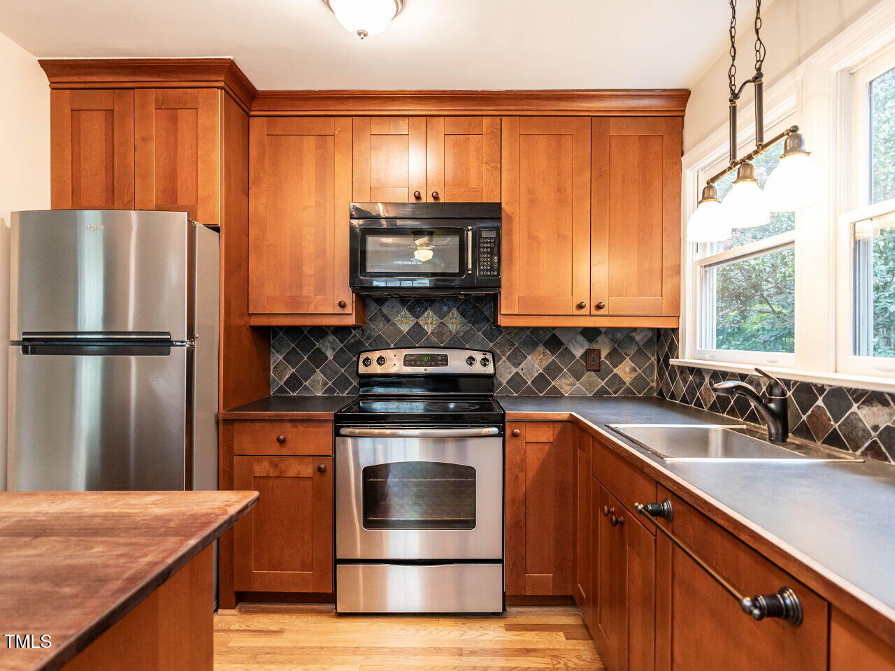 412 Morrison Avenue Raleigh, NC 27608 - Photo 8 of 26 a kitchen with granite countertop wooden cabinets stainless steel appliances and a window