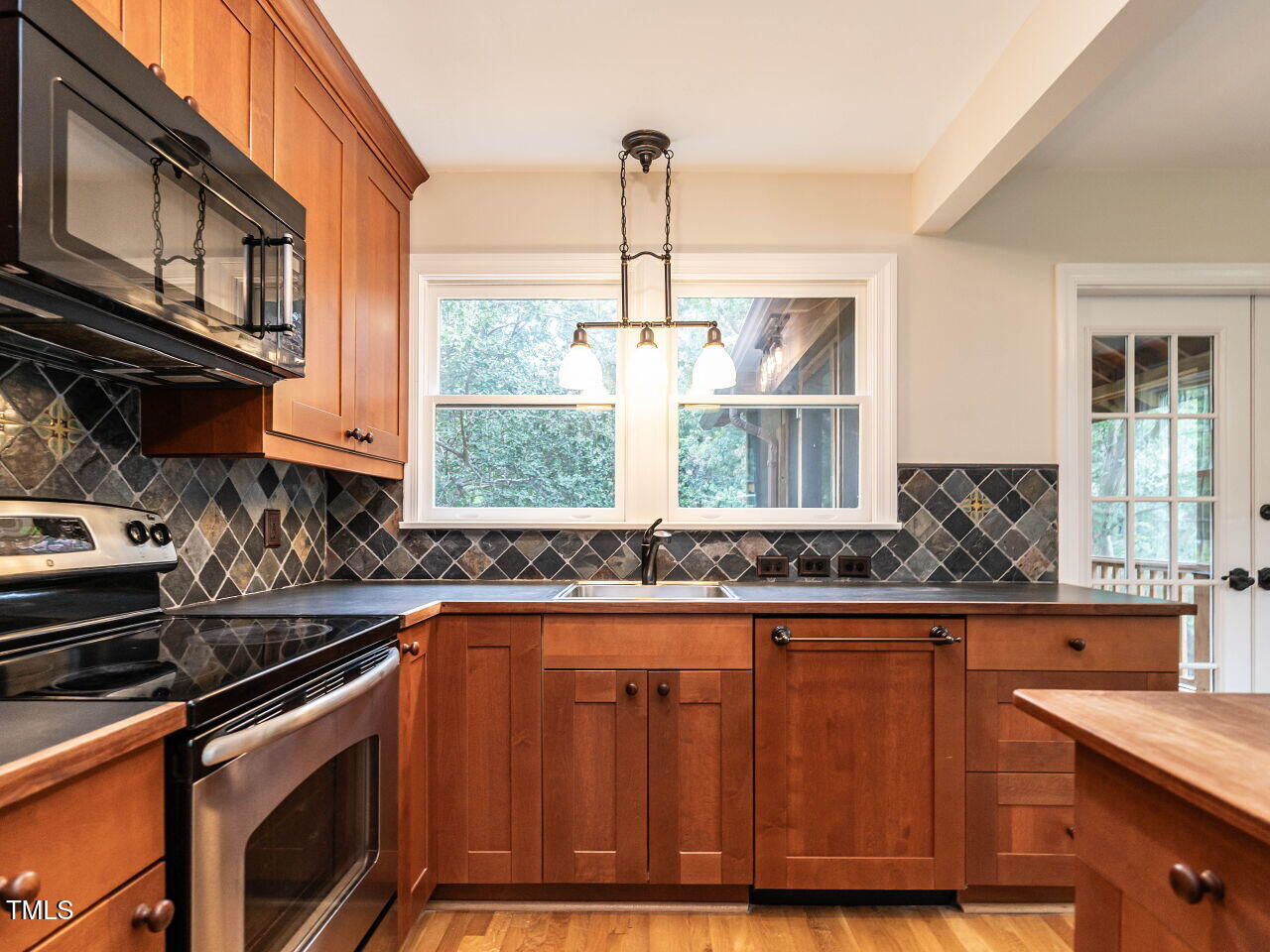 412 Morrison Avenue Raleigh, NC 27608 - Photo 10 of 26 a kitchen with stainless steel appliances granite countertop a sink a stove and a wooden floors