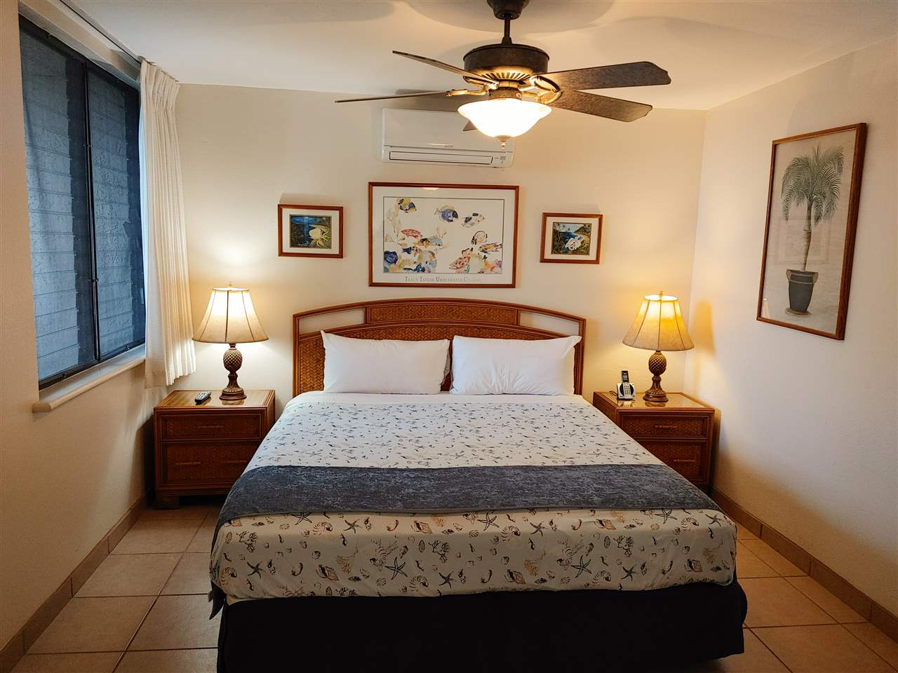5295 Lower Honoapiilani Road, Unit A24 Lahaina, HI 96761 - Photo 20 of 23 a bedroom with a bed and a chandelier