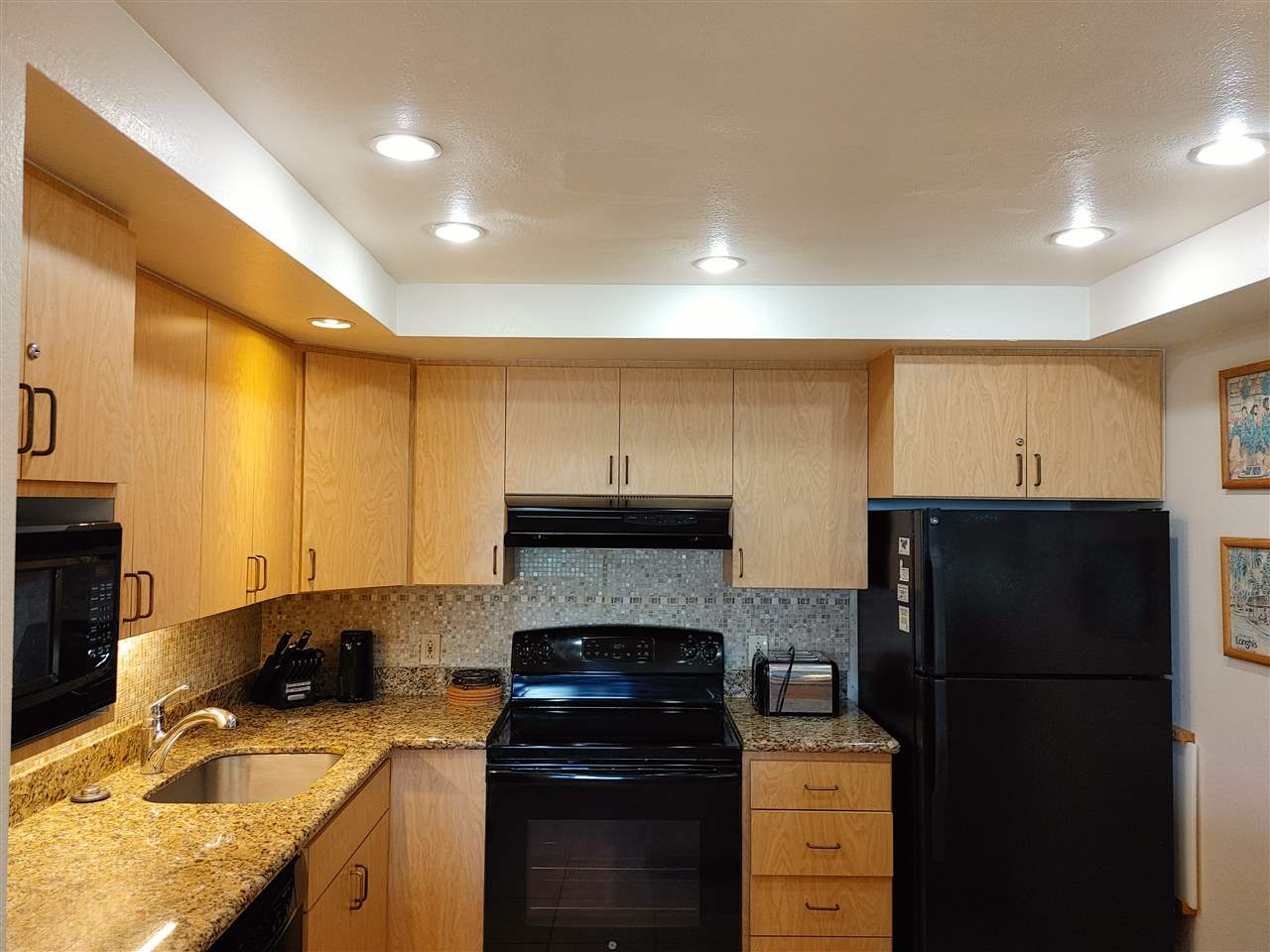 5295 Lower Honoapiilani Road, Unit A24 Lahaina, HI 96761 - Photo 2 of 23 a kitchen with a sink a refrigerator and cabinets