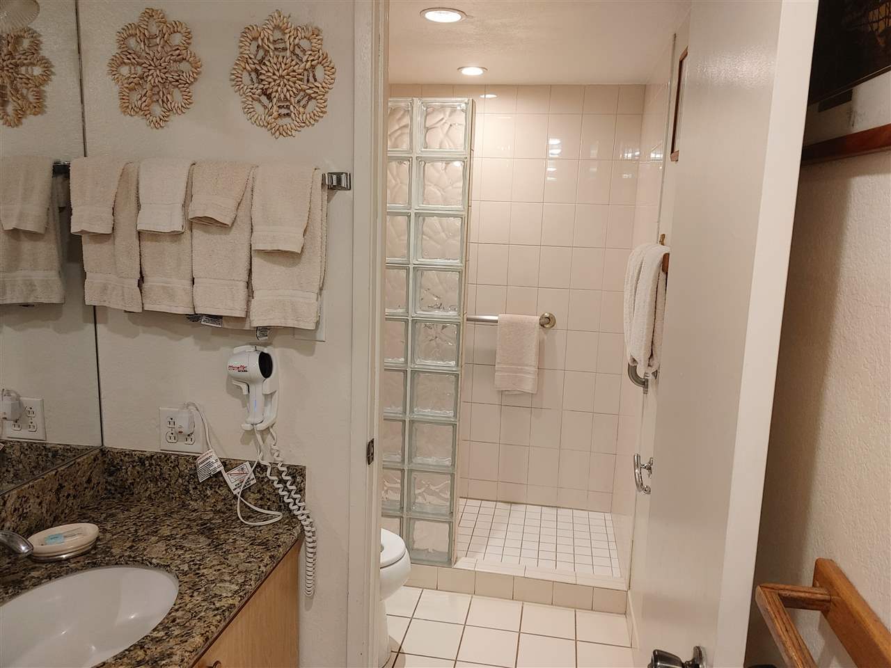 5295 Lower Honoapiilani Road, Unit A24 Lahaina, HI 96761 - Photo 6 of 23 a bathroom with a granite countertop sink a toilet and shower