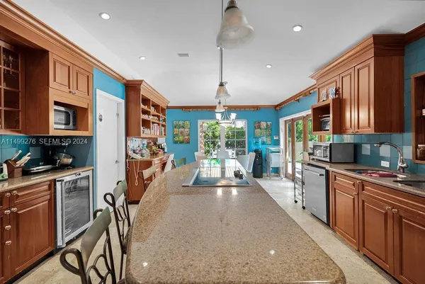 a large kitchen with stainless steel appliances granite countertop a lot of counter space and a wooden floor