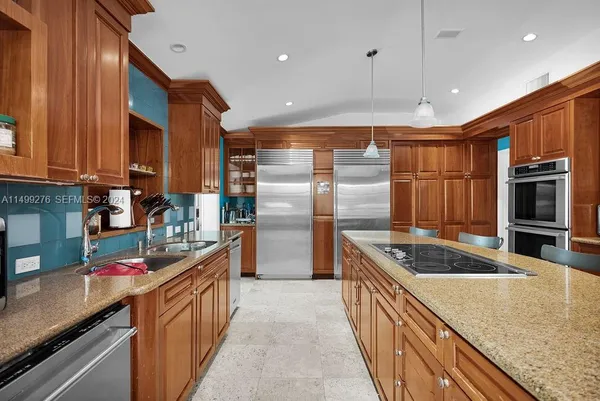 a kitchen with stainless steel appliances granite countertop a stove a sink and a refrigerator