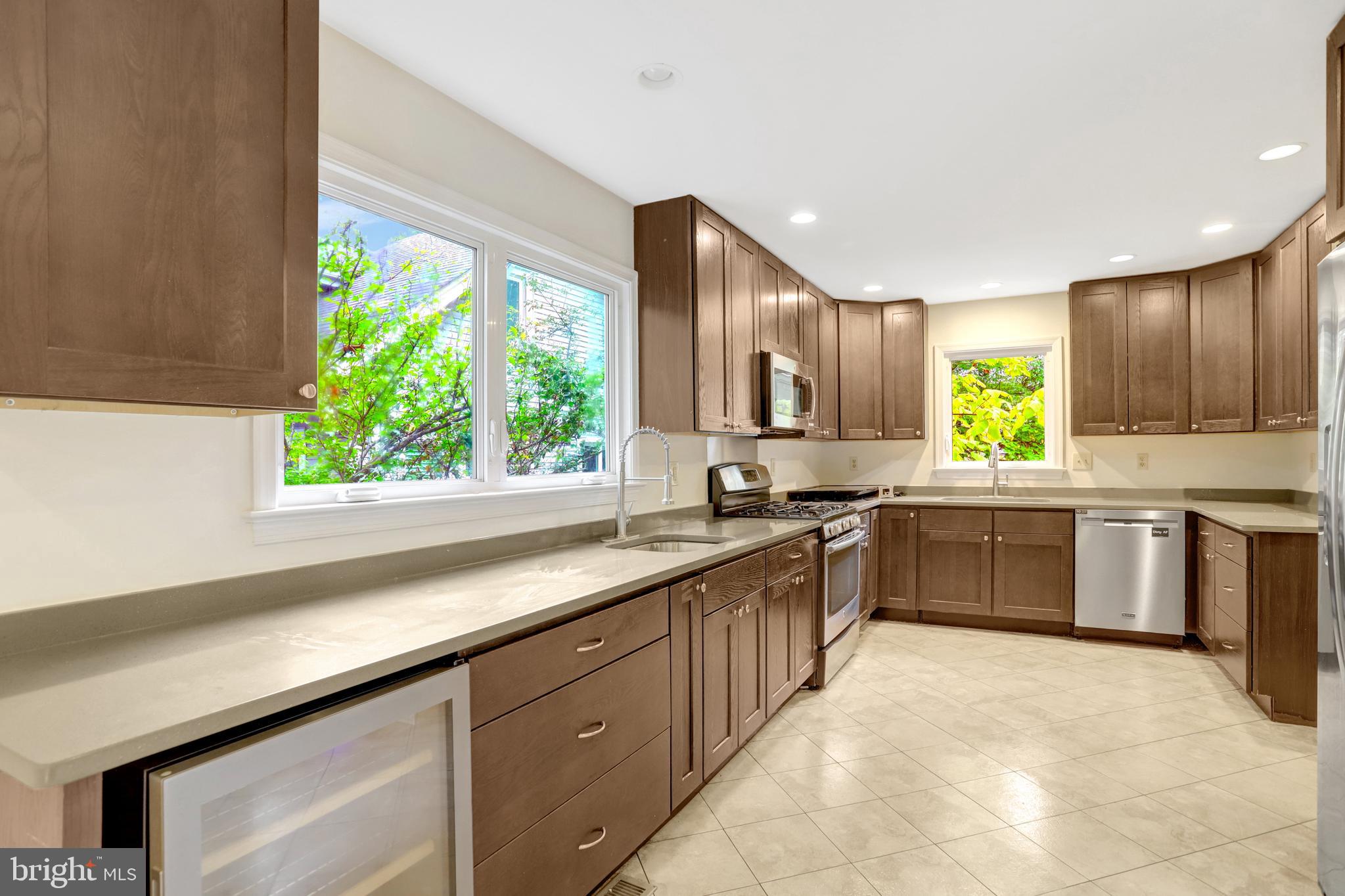 411 North Bryan Street Arlington, VA 22201 - Photo 16 of 58 a large kitchen with stainless steel appliances granite countertop wooden cabinets a stove a sink and a large window