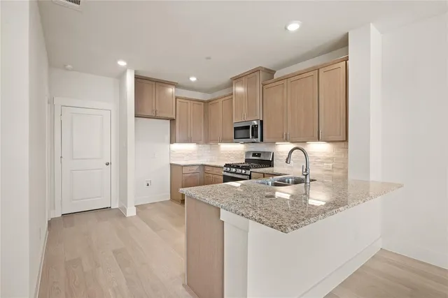 a kitchen with stainless steel appliances granite countertop a sink stove and refrigerator