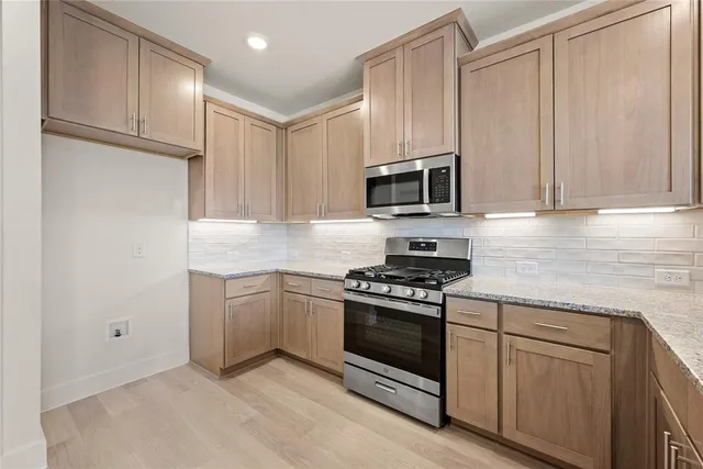 a kitchen with granite countertop cabinets stainless steel appliances and a sink
