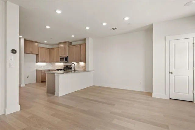a kitchen with a refrigerator and white cabinets