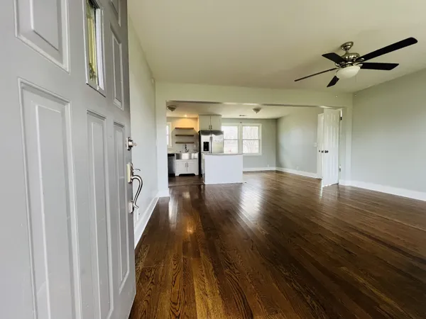 a view of a hallway with wooden floor and staircase