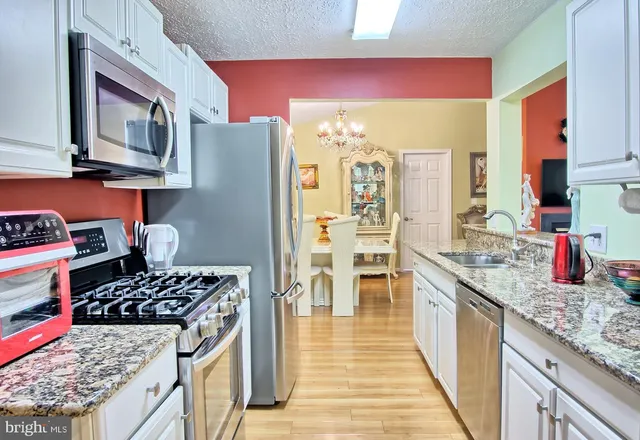 a kitchen with stainless steel appliances granite countertop a stove and a sink