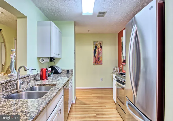 a kitchen with granite countertop a refrigerator and a sink