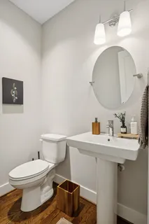 a bathroom with a toilet a sink and mirror